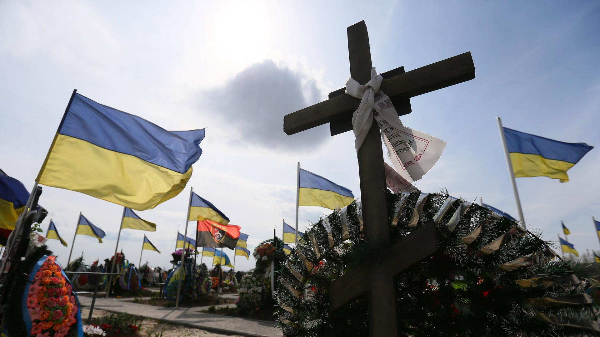 Flaggen und Kreuze auf Soldatengräbern einem Friedhof in der Stadt Brovary in Ukraine.