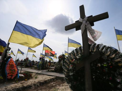 Flaggen und Kreuze auf Soldatengräbern einem Friedhof in der Stadt Brovary in Ukraine.