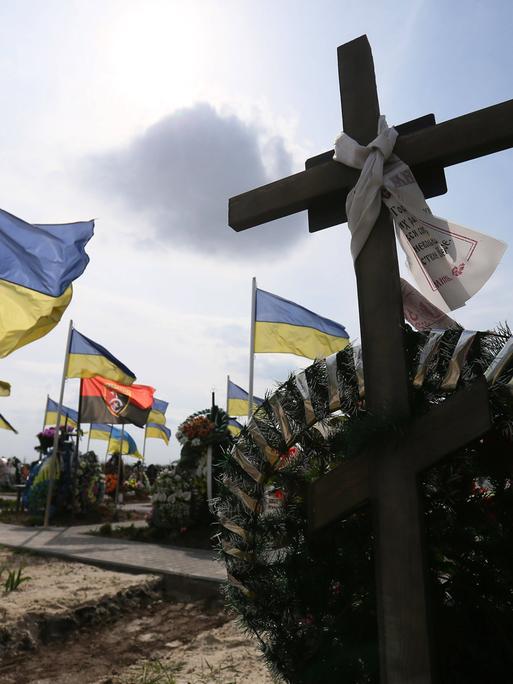 Flaggen und Kreuze auf Soldatengräbern einem Friedhof in der Stadt Brovary in Ukraine.