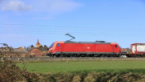 Güterzug mit Lokomotive der DB Cargo der Baureihe 185 Bombardier Traxx F140 AC1 auf der Bahnstrecke Hannover-Altenbeken. Die Lok ist rot, der Himmel blau.