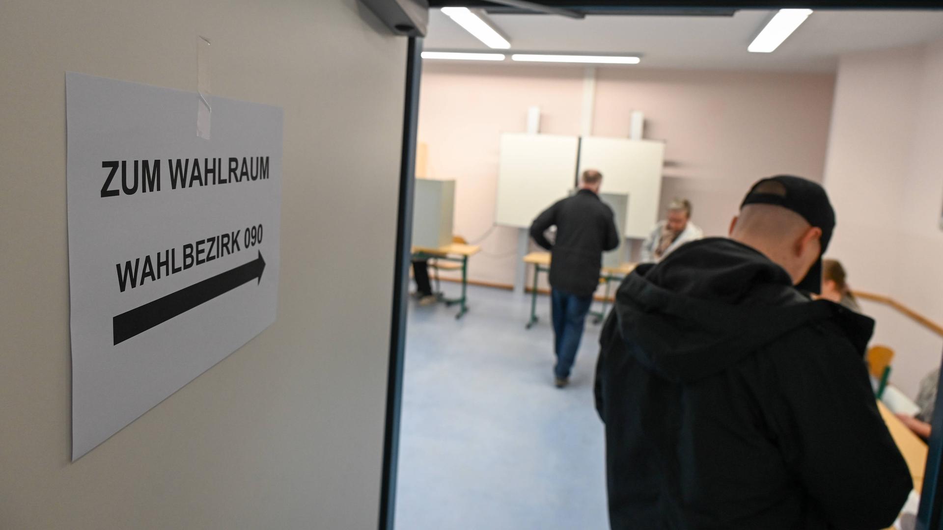 Menschen beteiligen sich im sächsischen Döbeln in einem Wahllokal an der Bundestagswahl.