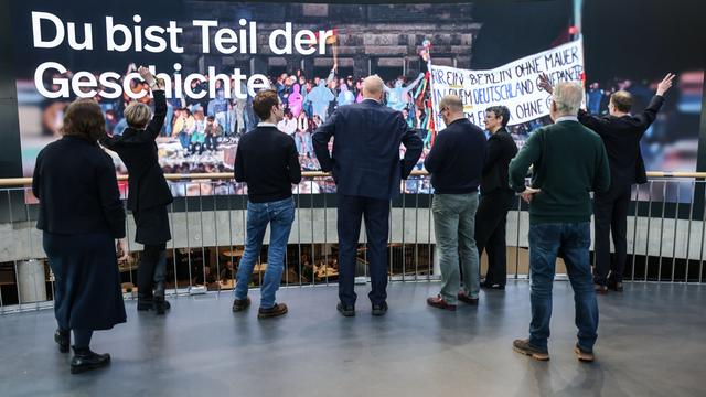 Der neue Slogan „Du bist Teil der Geschichte“ ist im Haus der Geschichte auf einer Videowand zu sehen, davor stehen Menschen. Das Haus der Geschichte in Bonn eröffnet seine neu gestaltete Dauerausstellung. Der neue Slogan „Du bist Teil der Geschichte“ ist im Haus der Geschichte auf einer Videowand zu sehen, davor stehen Menschen. Das Haus der Geschichte in Bonn eröffnet seine neu gestaltete Dauerausstellung.
