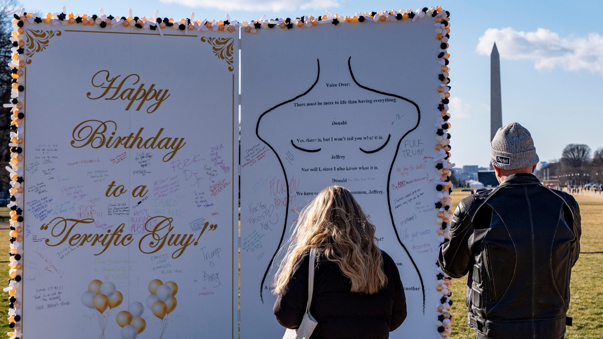 Menschen betrachten eine circa 3 Meter hohe Installation in Form einer Glückwunschkarte mit der Skizze einer nakten Frau. 