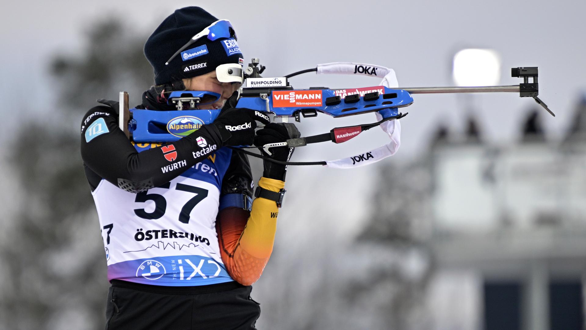 Franziska Preuß steht aufrecht vor einem Schießstand und legt konzentriert das Gewehr an. Aufnahme vom Biathlon-Weltcup in Östersund, Schweden am 26.11.2023. Franziska Preuß steht aufrecht vor einem Schießstand und legt konzentriert das Gewehr an. Aufnahme vom Biathlon-Weltcup in Östersund, Schweden am 26.11.2023.