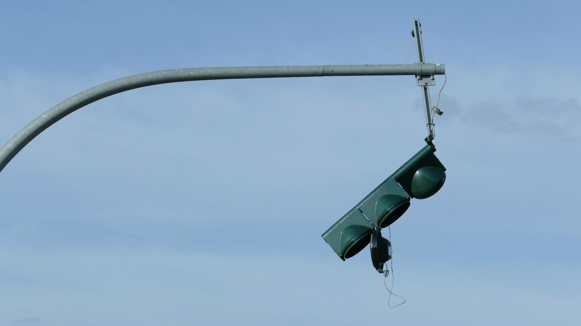 Eine Ampel ist nach einer Kollision außer Betrieb, zerstörte Kabel hängen herunter (Symbolbild).