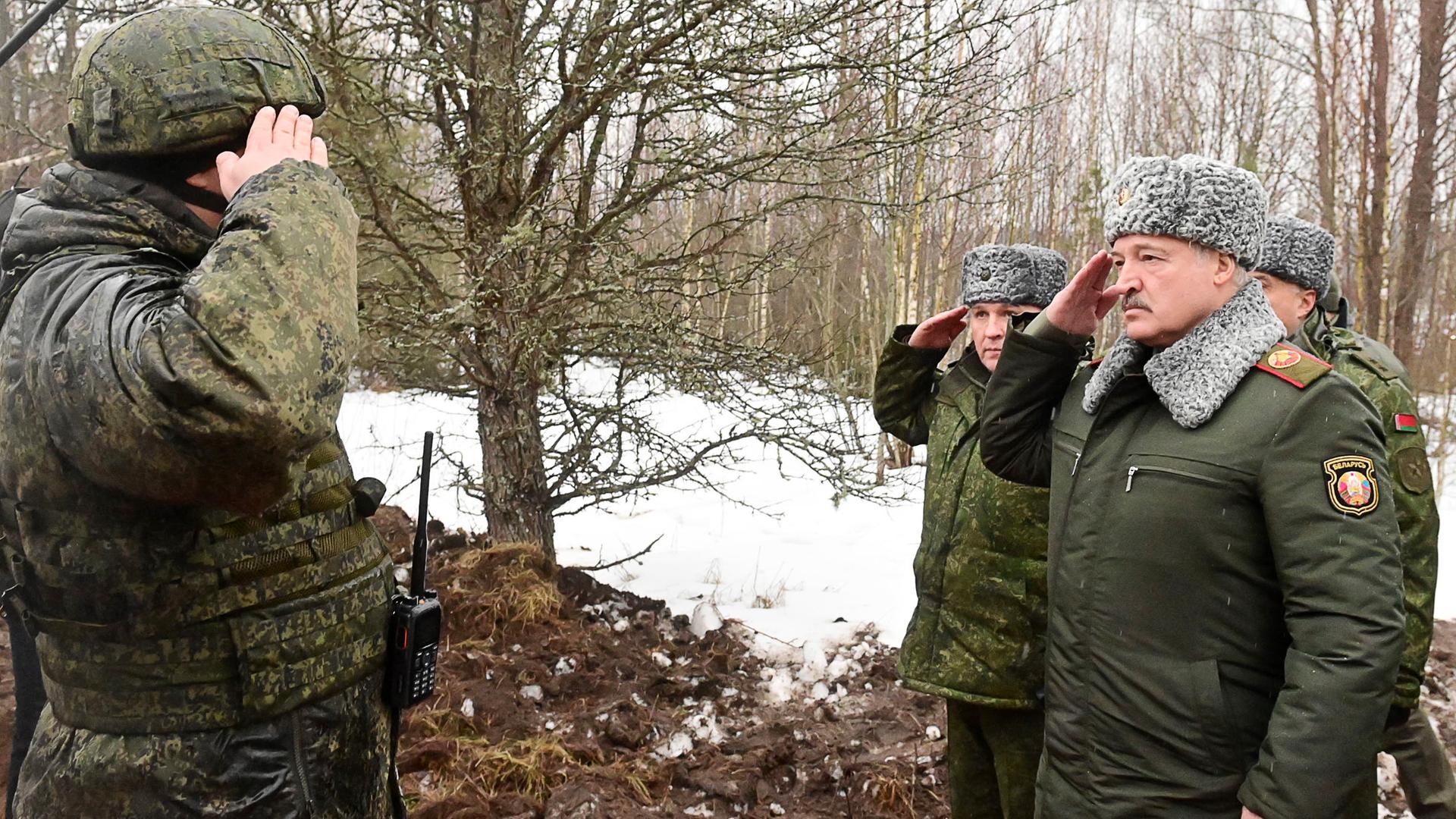 Alexander Lukaschenko in einer Militäruniform grüßt einen Angehörigen der Armee.