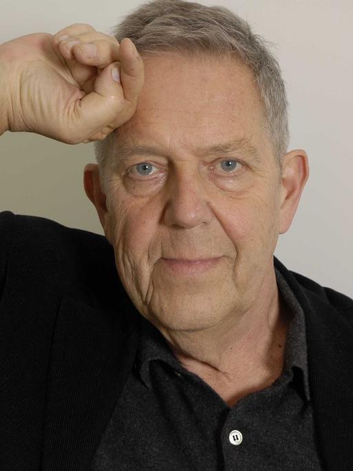 Portraitaufnahme des inzwischen verstorbenen Dichters Robert Gernhardt, eine Hand ist an die Stirn gelegt.