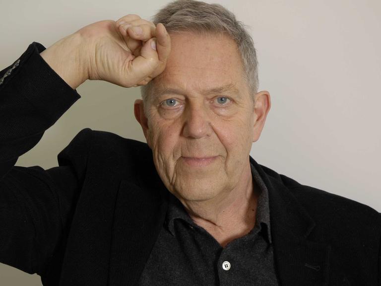 Portraitaufnahme des inzwischen verstorbenen Dichters Robert Gernhardt, eine Hand ist an die Stirn gelegt.