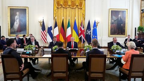 Donald Trump sitzt an einem Tisch mit dem britischen Premier Keir Starmer, Frankreichs Präsident Emmanuel Macron, Bundeskanzler Friedrich Merz, Ukraines Präsident Wolodymyr Selenskyj und EU-Kommissionspräsidentin Ursula von der Leyen