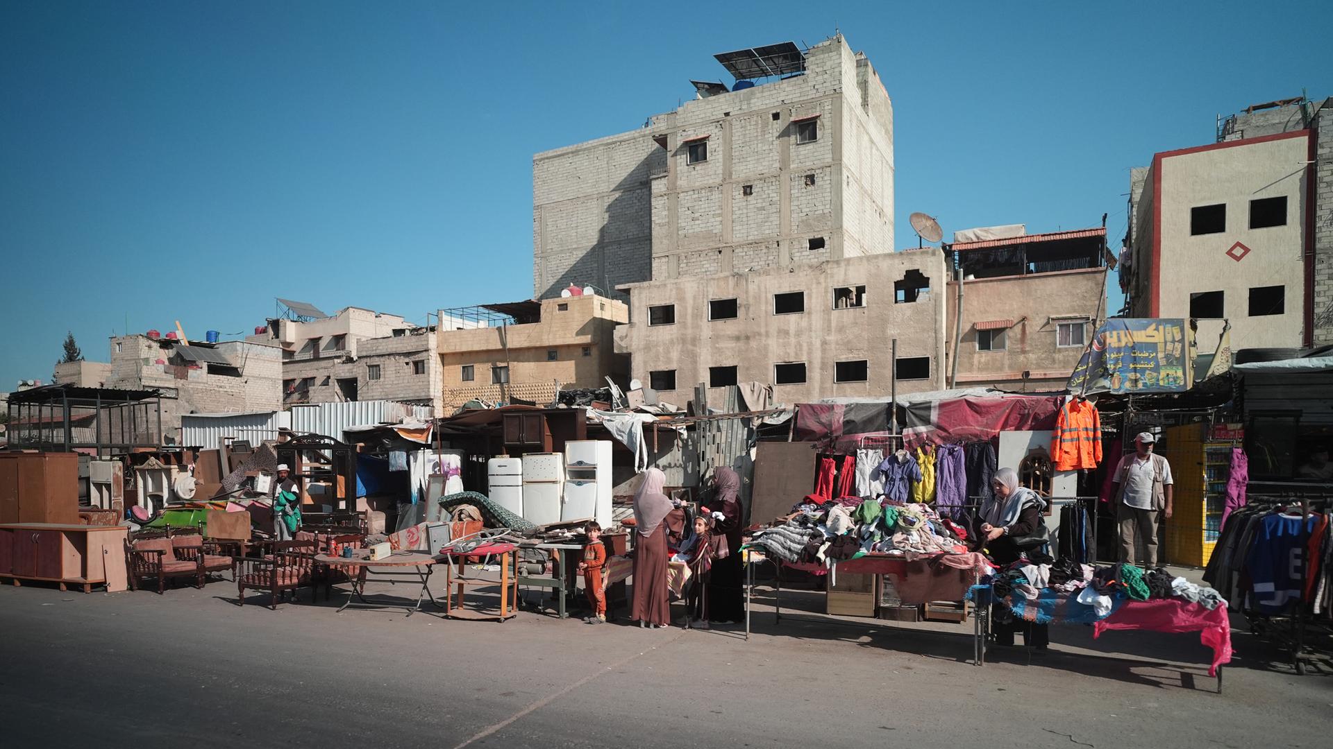 Straßenverkäufer bieten ihre Waren am Straßenrand eines durch den Bürgerkrieg zerstörten Stadtteils in Damaskus an. 