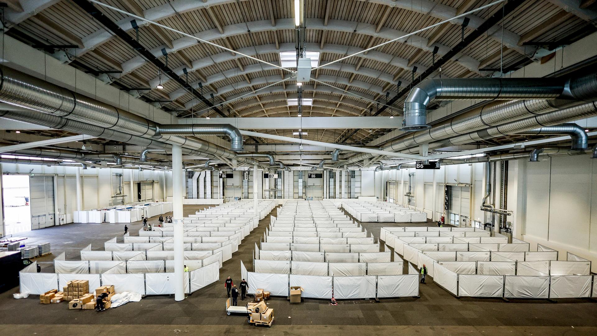 Arbeiter bereiten eine Messehalle in Hamburg für die Unterbringung von Schutzsuchenden aus der Ukraine vor.
