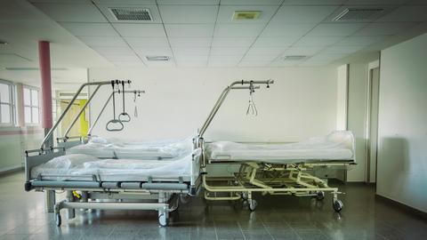 Leere Betten stehen in einem Gang eines Krankenhauses.