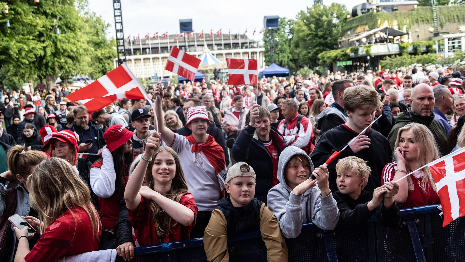 Dänische Fußball-Fans stehen mit Fahnen vor einer Bühne im Freizeitpark Tivoli in Kopenhagen.