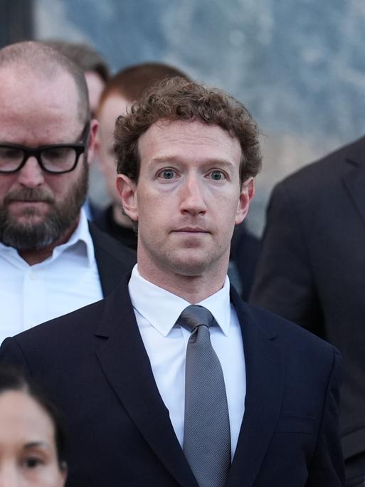 Mark Zuckerberg mit mehreren Menschen vor Gerichtsgebäude Mark Zuckerberg mit mehreren Menschen vor Gerichtsgebäude