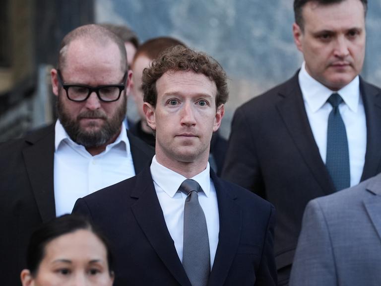 Mark Zuckerberg mit mehreren Menschen vor Gerichtsgebäude Mark Zuckerberg mit mehreren Menschen vor Gerichtsgebäude