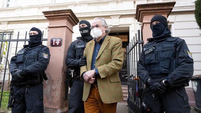 Bei einer Razzia gegen sogenannte «Reichsbürger» führen vermummte Polizisten, nach der Durchsuchung eines Hauses Heinrich XIII Prinz Reuß (2.v.r.) zu einem Polizeifahrzeug.