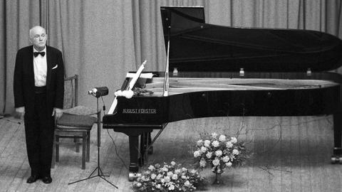 Wir sehen einen Pianisten vor einem Flügel stehen. 