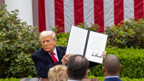 US-Präsident Donald Trump hält vor Zuschauern eine Durchführungsverordnung über „reziproke Zölle“ hoch. Im Hintergrund ist die US-Flagge zu sehen.