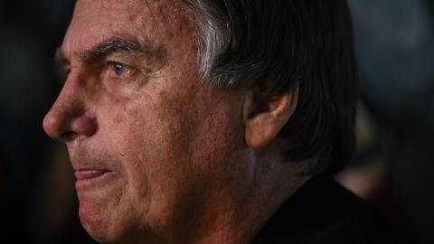 Brasiliens Ex-Präsident Bolsonaro gestikuliert, während er mit Medienvertretern spricht. 