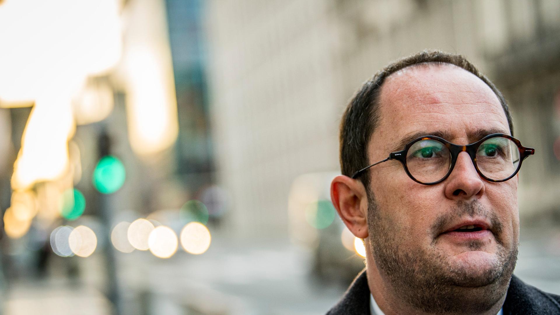 Portraitfoto des Politikers an einer Straße zwischen Gebäuden