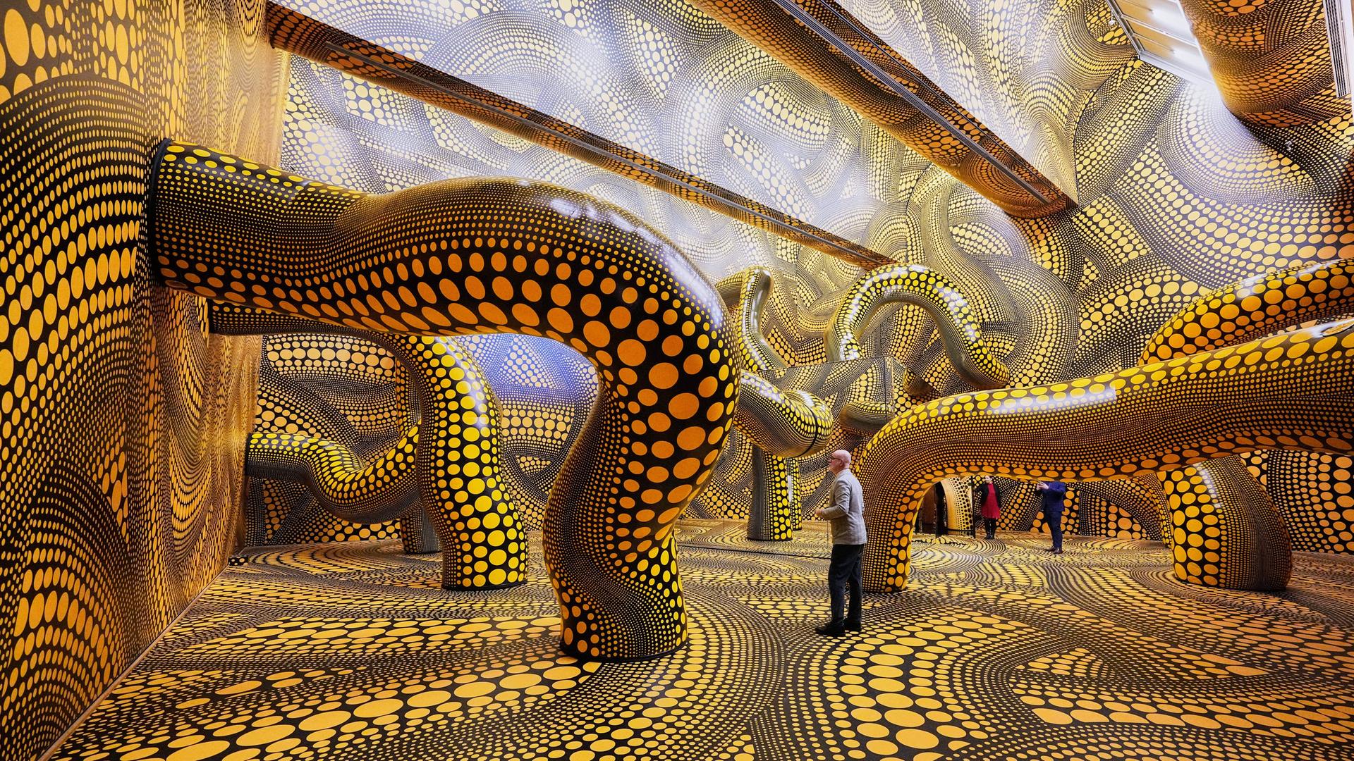 Besucher der Ausstellung im Kölner Museum Ludwig gehen durch das Werk "Infinity Mirrored Room" der legendären japanischen Künstlerin Yayoi Kusama.