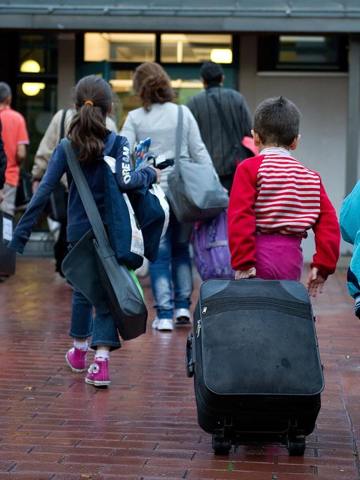 Flüchtlinge aus Syrien, zum Teil mit Rollkoffer, kommen am 11.09.2013 im Grenzdurchgangslager Friedland (Niedersachsen) an. 