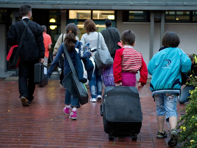 Flüchtlinge aus Syrien, zum Teil mit Rollkoffer, kommen am 11.09.2013 im Grenzdurchgangslager Friedland (Niedersachsen) an. 