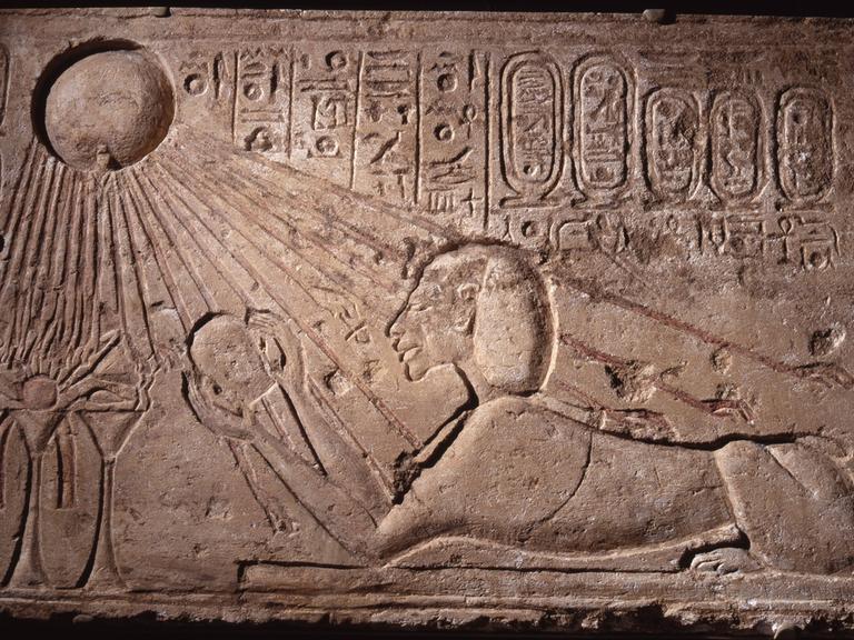 Ein Relief zeigt Echnaton als Sphinx, die die Gottheit Aton anbetet, dargestellt als Sonnenscheibe. 