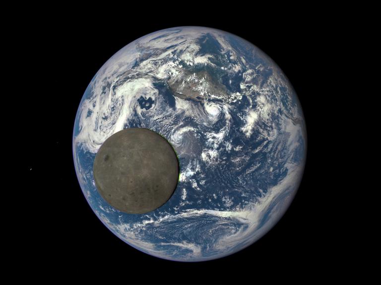 Der Mond vor der Erde aus dem Weltall betrachtet.