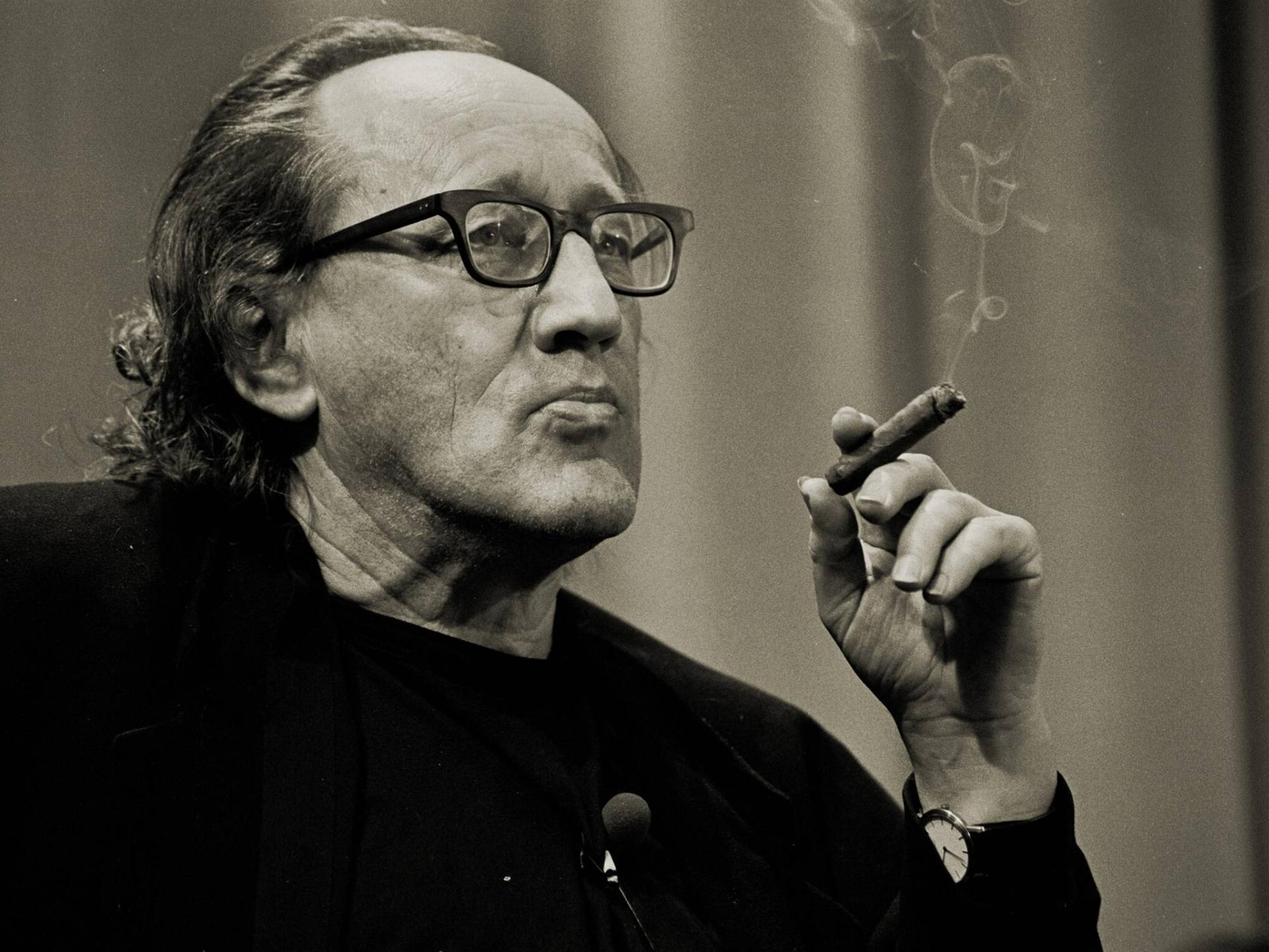 Sepiafarbenes Porträt von Heiner Müller, der in Gedanken verloren eine Zigarre raucht