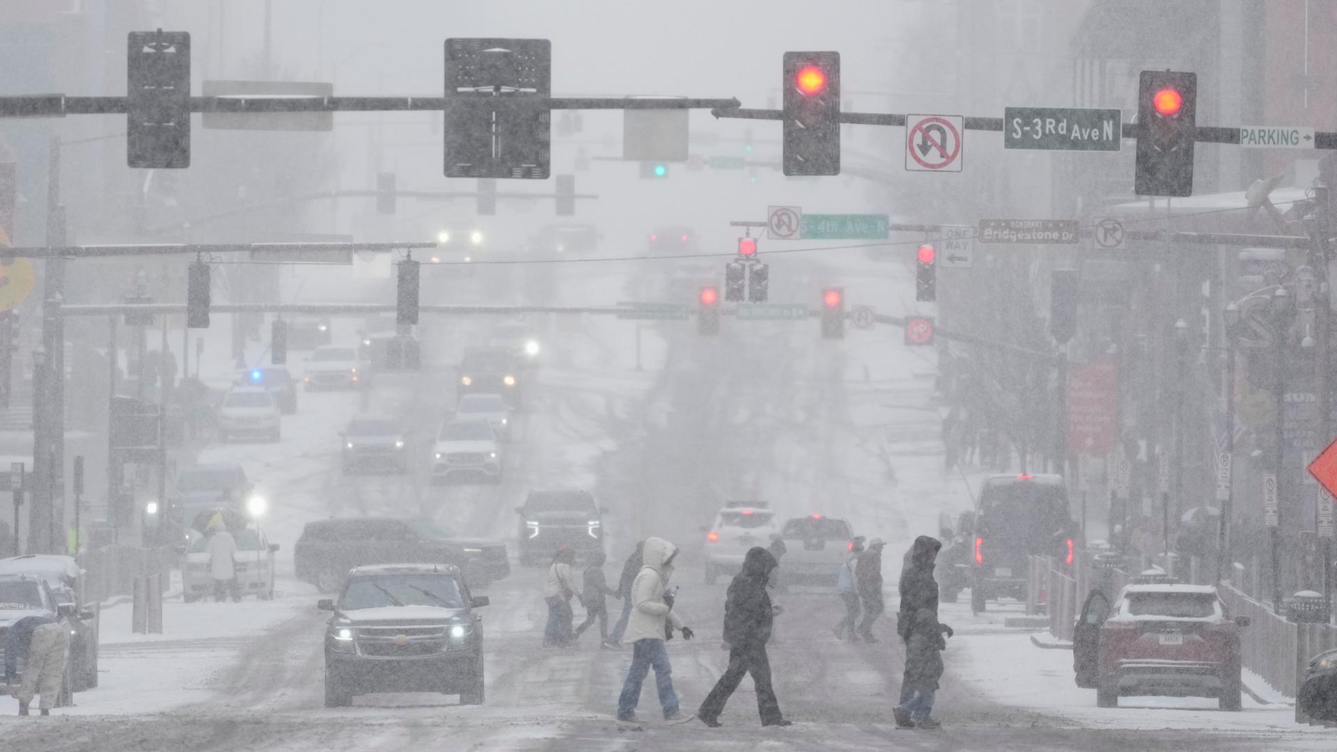 Fußgänger überqueren eine Straße während eines Winter-Sturms 