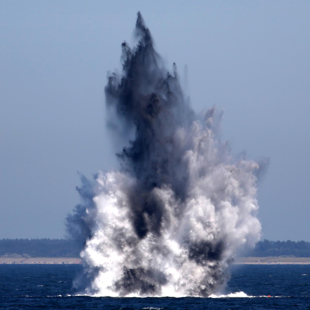 Eine Detonation auf dem Wasser ist zu sehen. 