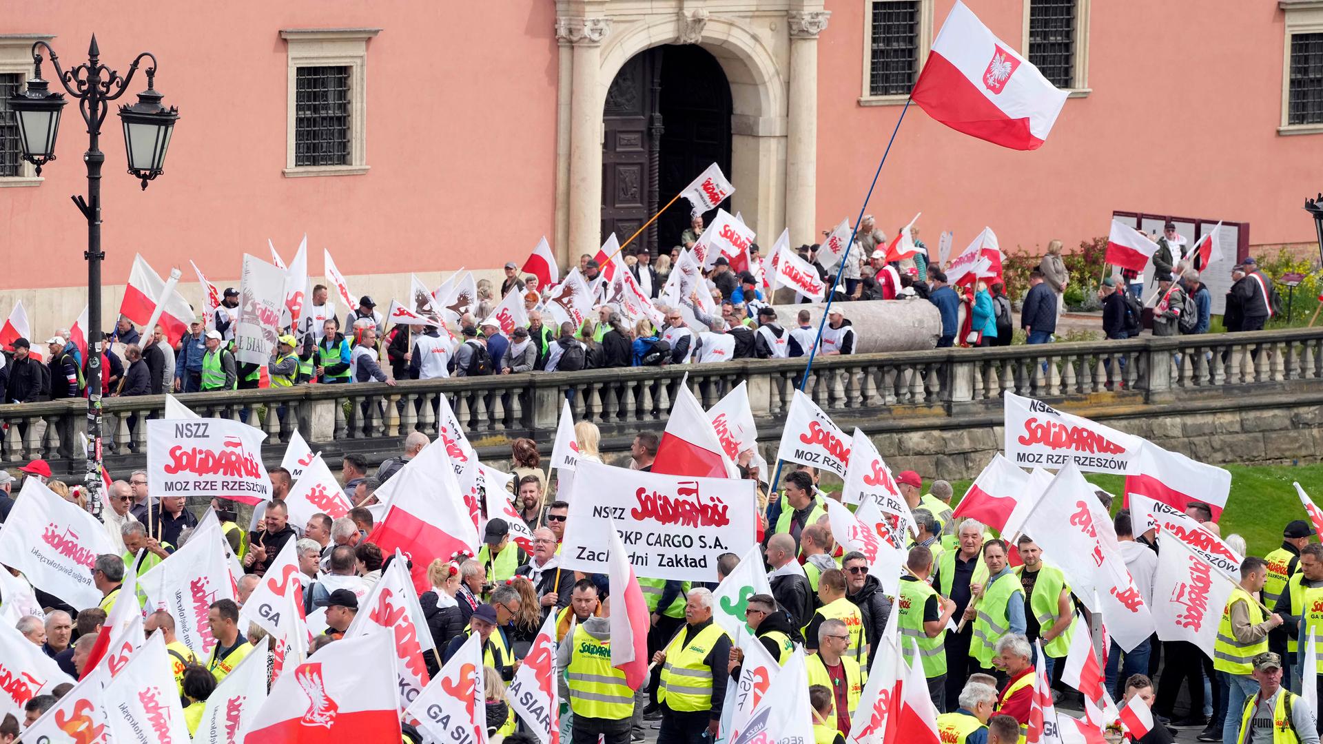 Polnische Landwirte und andere Demonstranten versammeln sich in der Warschauer Innenstadt, schwecken die weiß-rote Nationalflagge und zeigen Schilder.