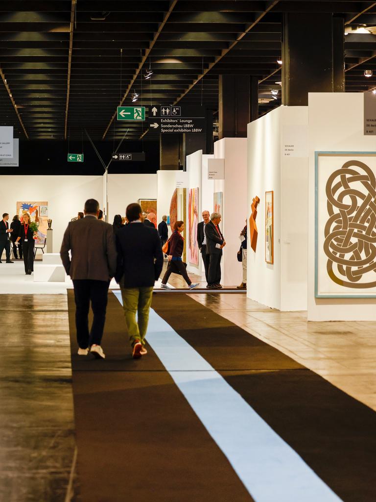 Besucher gehen bei der Eröffnung der Kunstmesse der Art Cologne durch die Hallen.