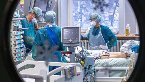 Ärzte und Pflegekräfte betreuen einen Patienten auf der Intensivstation. Ärzte und Pflegekräfte betreuen einen Patienten auf der Intensivstation.