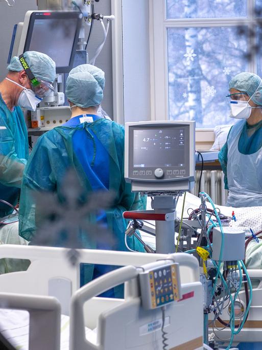 Ärzte und Pflegekräfte betreuen einen Patienten auf der Intensivstation.