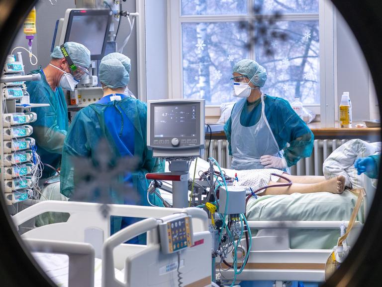 Ärzte und Pflegekräfte betreuen einen Patienten auf der Intensivstation.