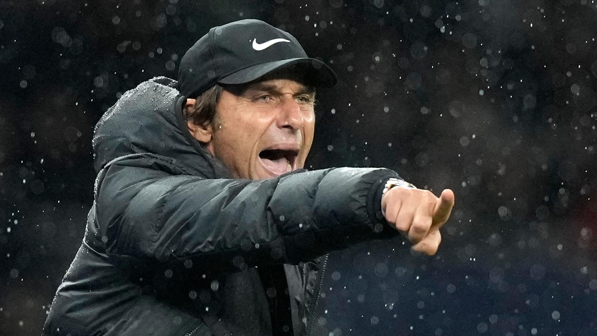 Trainer Antonio Conte, beim Spiel Tottenham Hotspur gegen Newcastle United. Er steht mit einer Kappe im Regen, zeigt mit dem Finger auf etwas und scheint laut etwas zu rufen. Trainer Antonio Conte, beim Spiel Tottenham Hotspur gegen Newcastle United. Er steht mit einer Kappe im Regen, zeigt mit dem Finger auf etwas und scheint laut etwas zu rufen.