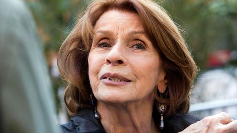 Großaufnahme von Senta Berger, die in die Kamera blickt.