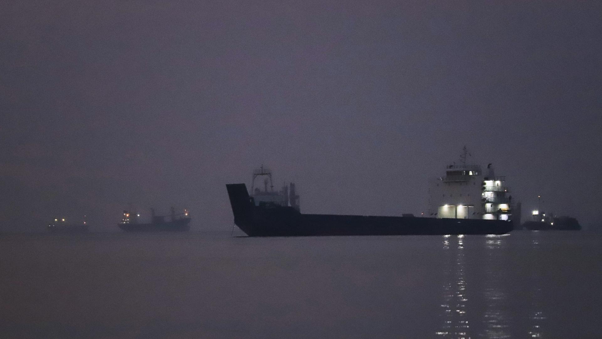 Iran, Bandar Abbas: Vor Sonnenaufgang liegen Frachtschiffe in der Straße von Hormus vor Bandar Abbas vor Anker. 