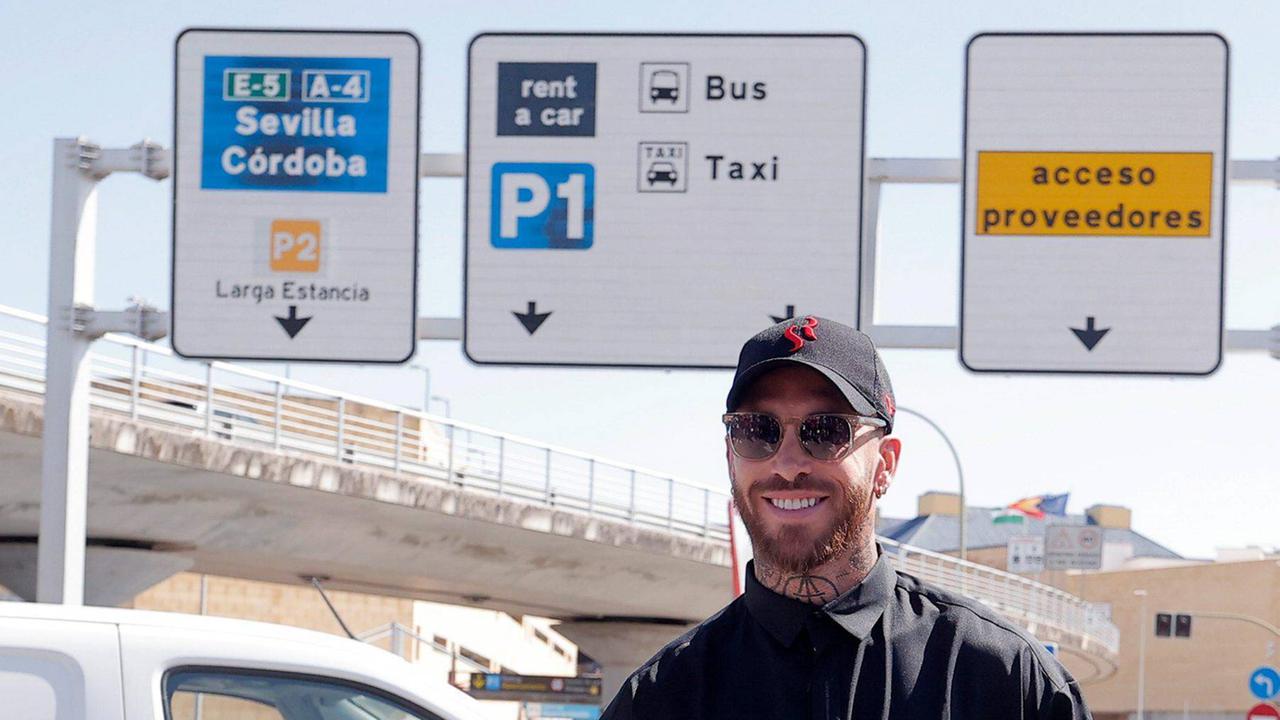 Sergio Ramos zeigt beide Daumen nach oben und lächelt. Im Hintergrund sind Straßenschilder mit dem Schriftzug "Sevilla" zu erkennen.