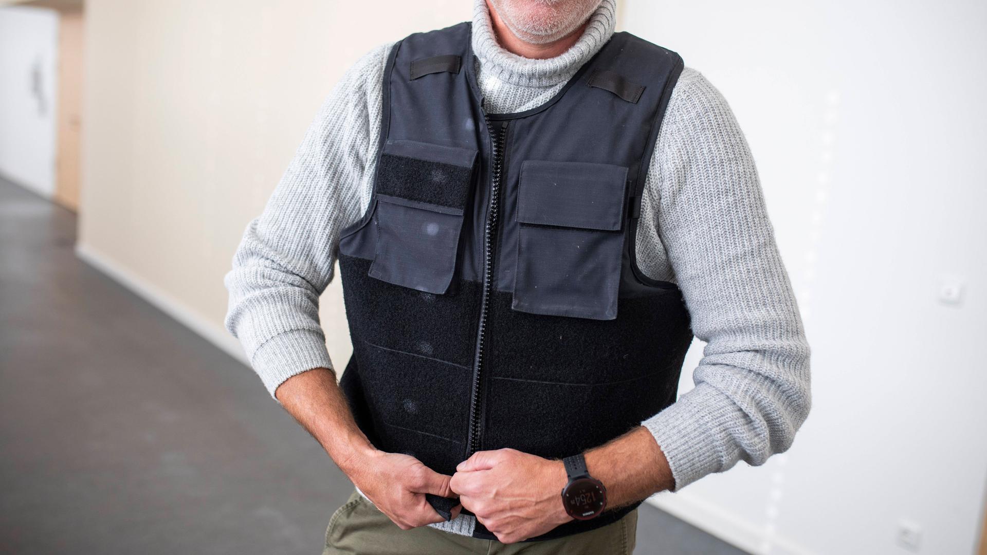 Ein Mann trägt eine schusssichere Weste. 