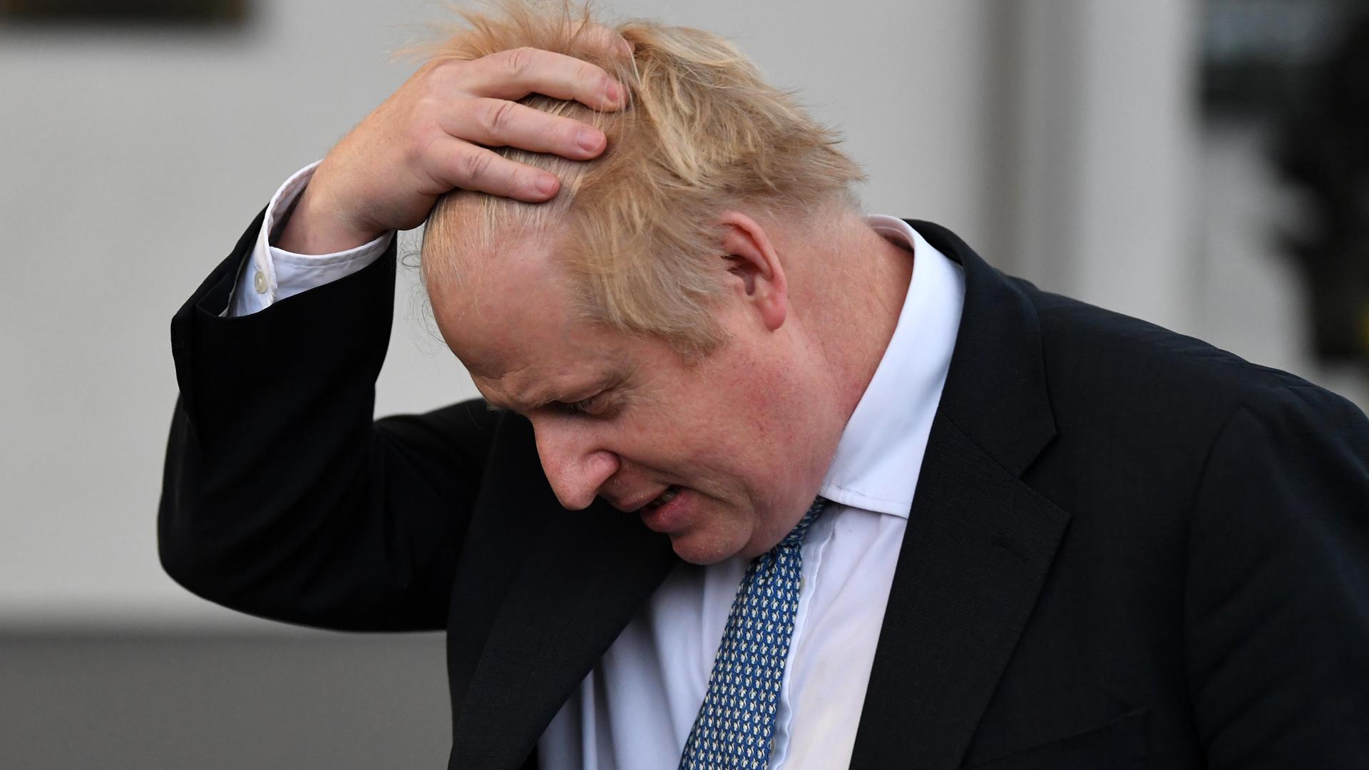 Großbritanniens Premierminister Boris Johnson streicht sich erschöpft durch sein Haar.