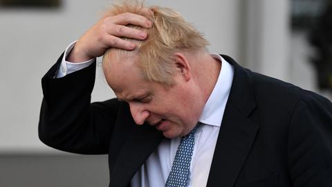 Großbritanniens Premierminister Boris Johnson streicht sich erschöpft durch sein Haar.
