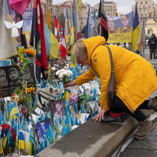 Eine Frau legt Blumen am Denkmal für die gefallenen ukrainischen Soldaten auf dem Unabhängigkeitsplatz in Kiew ab.