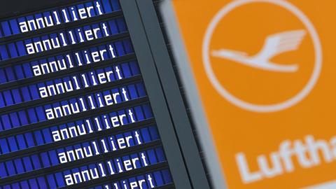 Eine Anzeigetafel mit der sich wiederholenden Aufschrift "annulliert". Daneben das Logo der Lufthansa mit einem Kranich. 