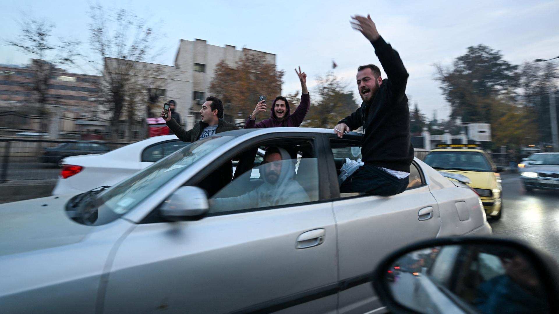 Menschen in einem Auto jubeln. Die Aufnahme ist aus der syrischen Hauptstadt Damaskus.