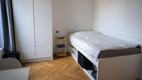 Die Werkswohnung der Charité in Berlin ist mit einem Bett, einem Nachttisch, einem Kleiderschrank und einem Stuhl möbliert.