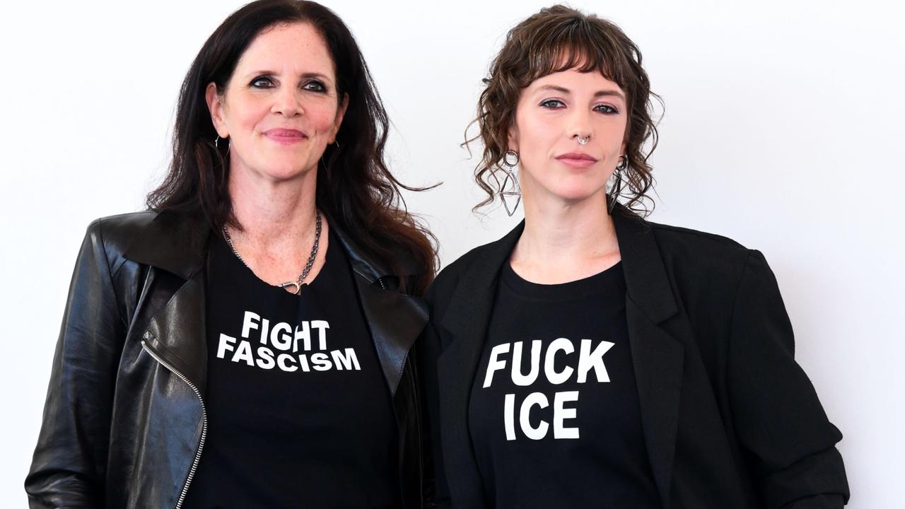 Die Filmemacherinnen Laura Poitras (links) und Rachel Lauren Mueller (rechts) ganz in schwarz gekleidet. Auf dem T-Shirt von Poitras steht "Fight Faschism" (Bekämpfe Faschismus), auf dem T-Shirt von Mueller "Fuck ICE". 
