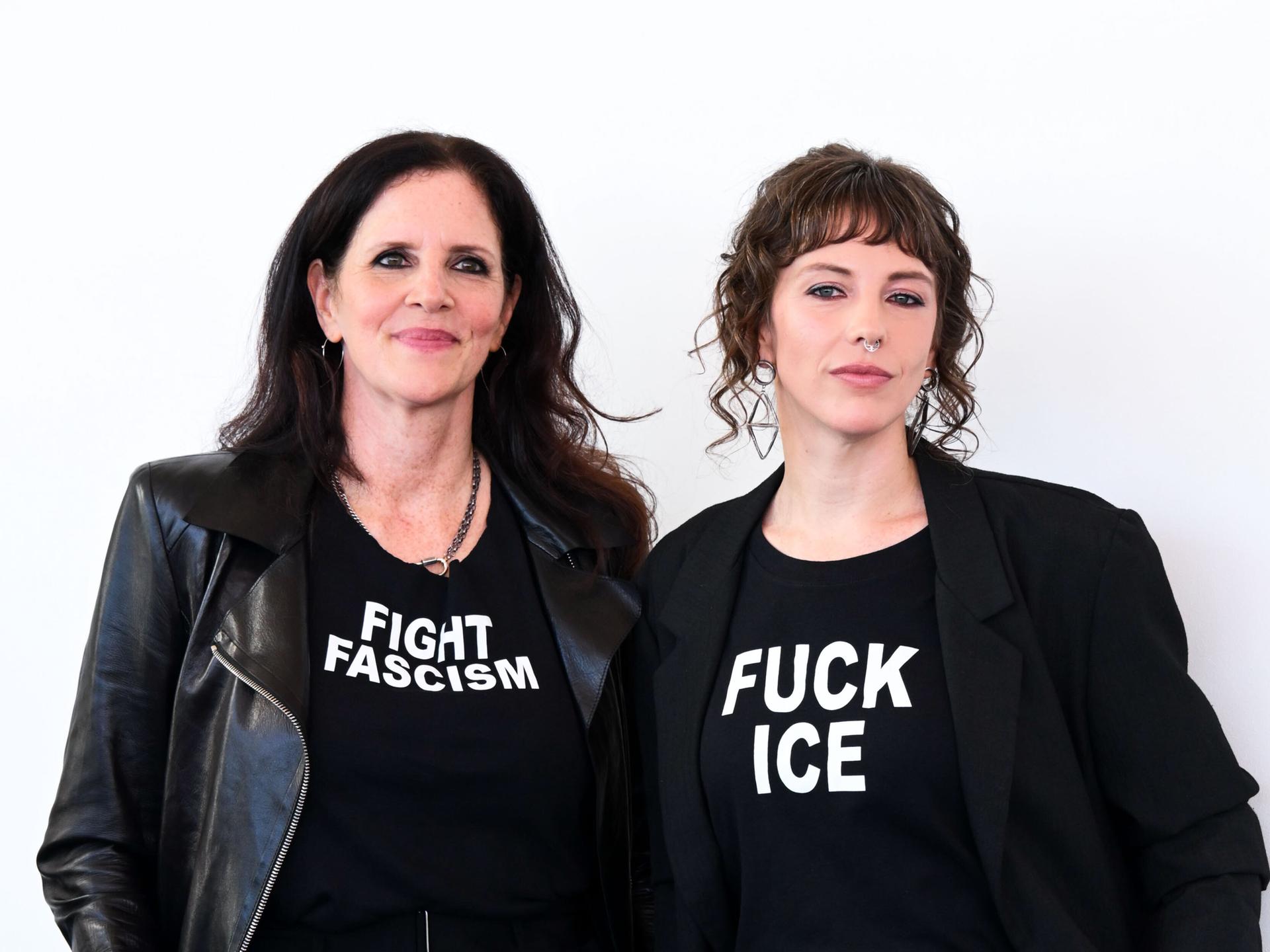 Die Filmemacherinnen Laura Poitras (links) und Rachel Lauren Mueller (rechts) ganz in schwarz gekleidet. Auf dem T-Shirt von Poitras steht "Fight Faschism" (Bekämpfe Faschismus), auf dem T-Shirt von Mueller "Fuck ICE". Die Filmemacherinnen Laura Poitras (links) und Rachel Lauren Mueller (rechts) ganz in schwarz gekleidet. Auf dem T-Shirt von Poitras steht "Fight Faschism" (Bekämpfe Faschismus), auf dem T-Shirt von Mueller "Fuck ICE".